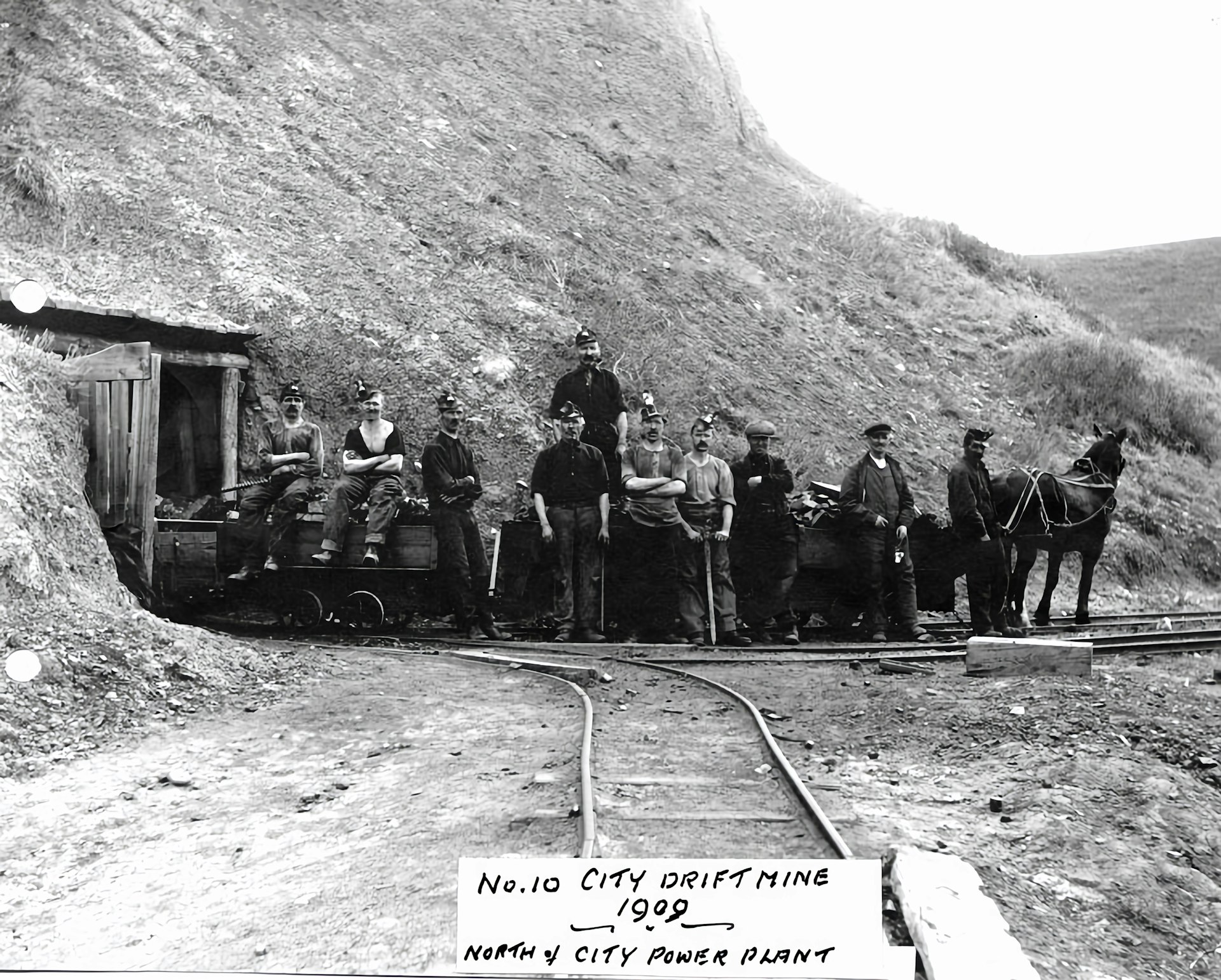 a group of men standing next to a train on a track